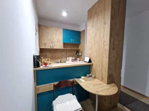 Small kitchen with wooden cabinetry, turquoise details, and a breakfast bar. - image 7