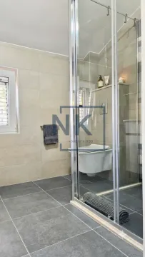 Savremeno opremljeno kupatilo sa tuš kabinom i keramičkim pločicama. - image 7