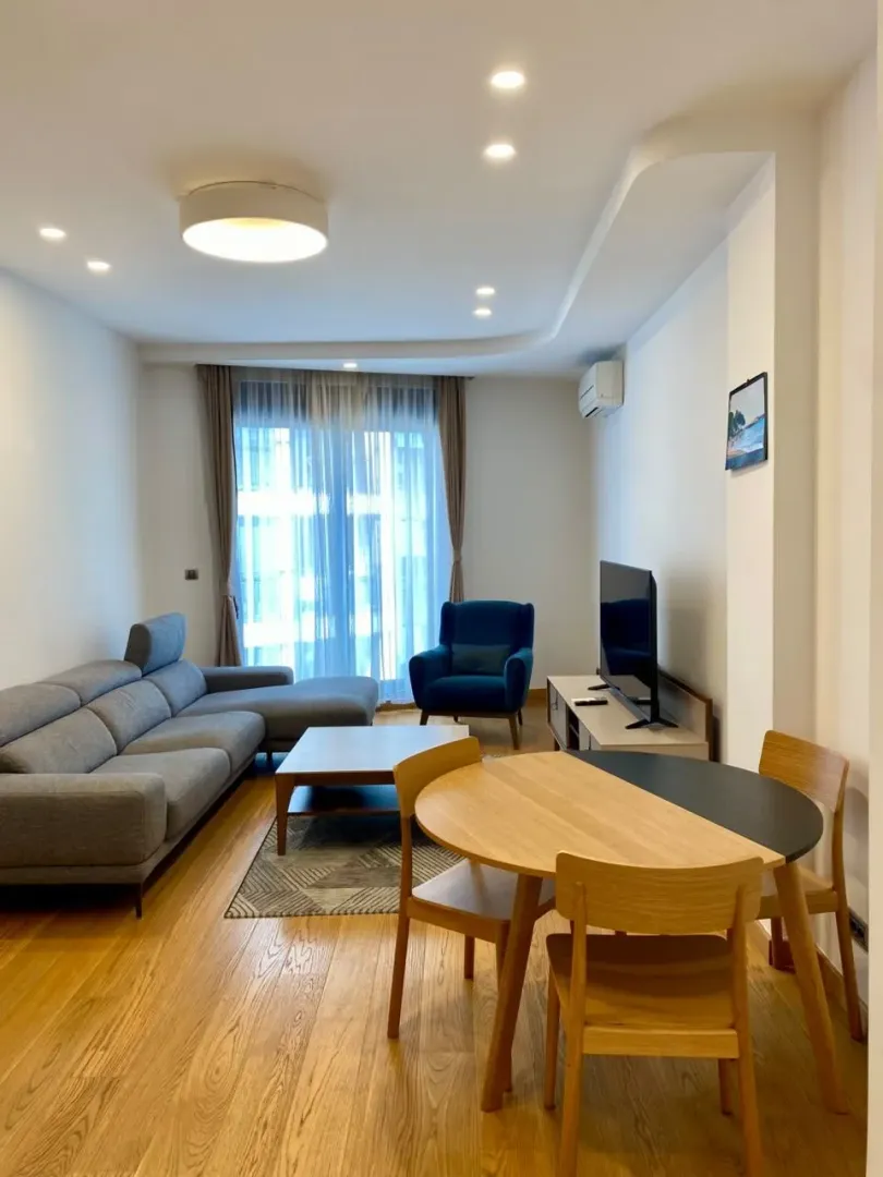 Spacious living room with a sofa set, dining table, and TV unit.