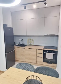 Modern kitchen with built-in cabinetry and a dark refrigerator. - image 6