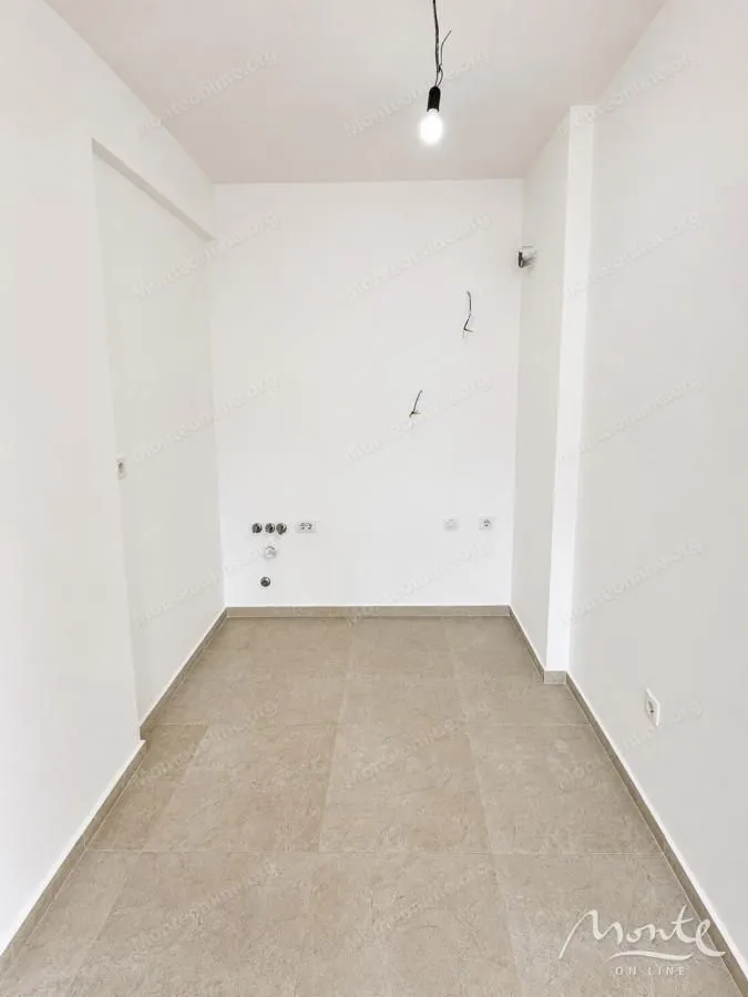 Prazna prostorija sa popločanim podom i priključcima za struju.