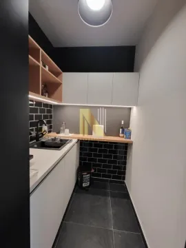Manja moderna kuhinja sa belim elementima i crnim zidnim pločicama. - image 7