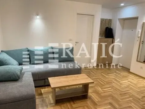 Living room with a sectional sofa and a wooden coffee table. - image 2