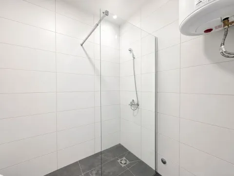 Moderne kupatilo sa tuš kabinom od stakla i bijelim pločicama. - image 13