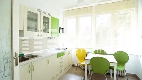 Bright kitchen with a dining area and green details.