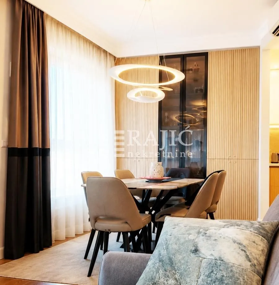 Living room with dining area and modern lighting.