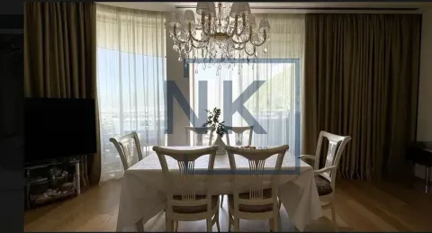 Living room with a dining table and chairs, large windows, and a chandelier. - image 5