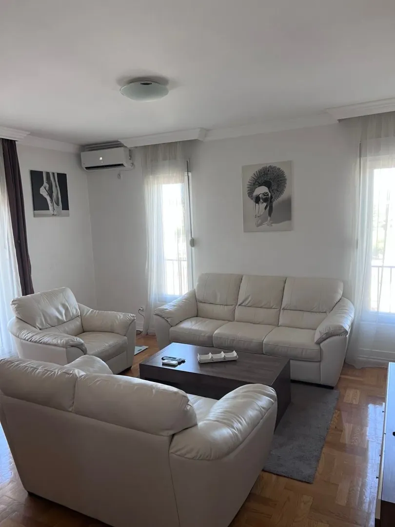 Svijetao i uredan dnevni boravak sa garniturom za sjedenje.