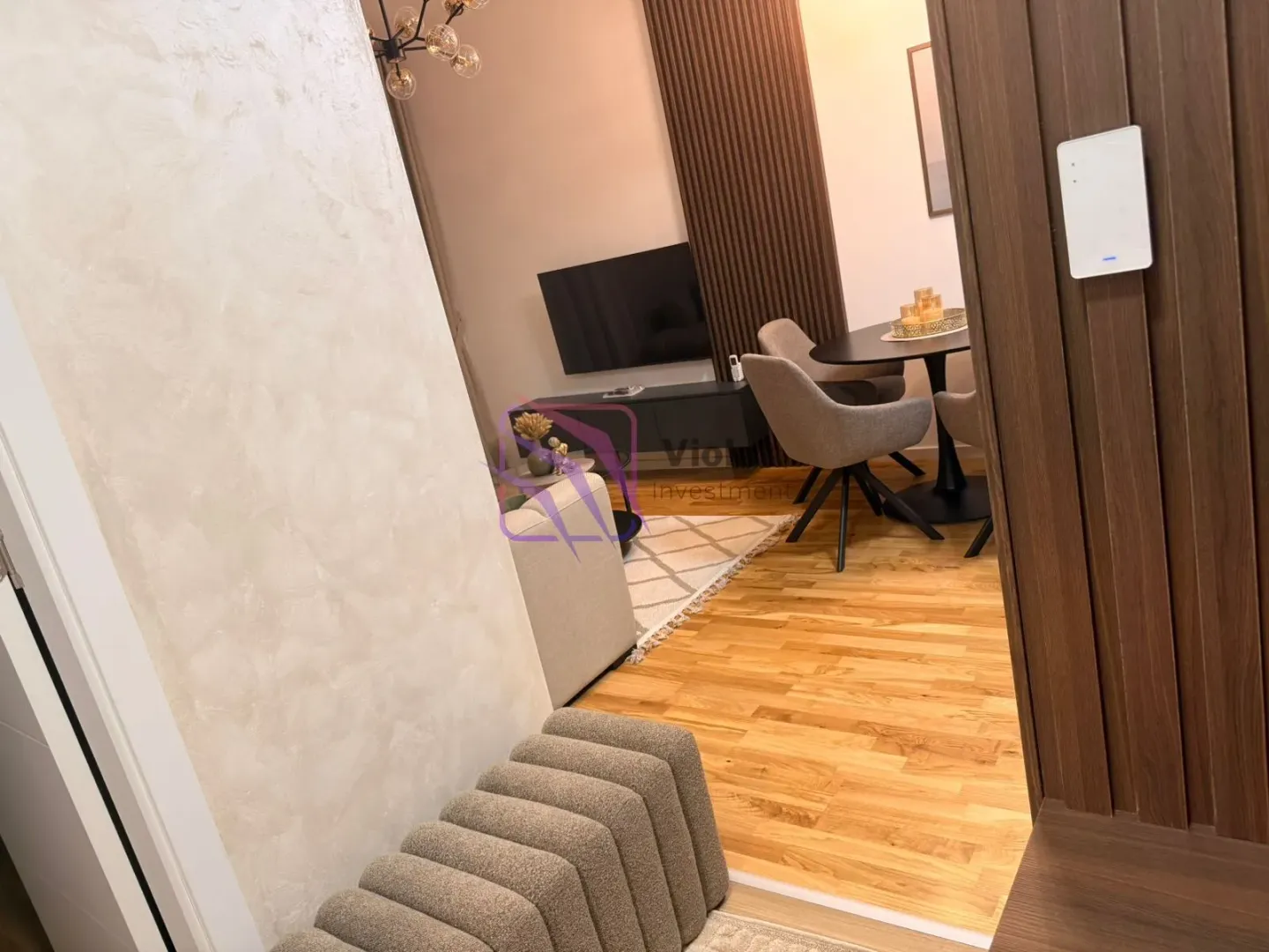 Pogled iz hodnika na moderno opremljenu dnevnu sobu i trpezariju.