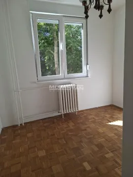 Prazna soba sa parketom i prozorom koji gleda na zelenilo. - image 11