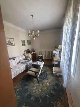 Small living room with a sofa, armchair, rug, and chandelier. - image 10