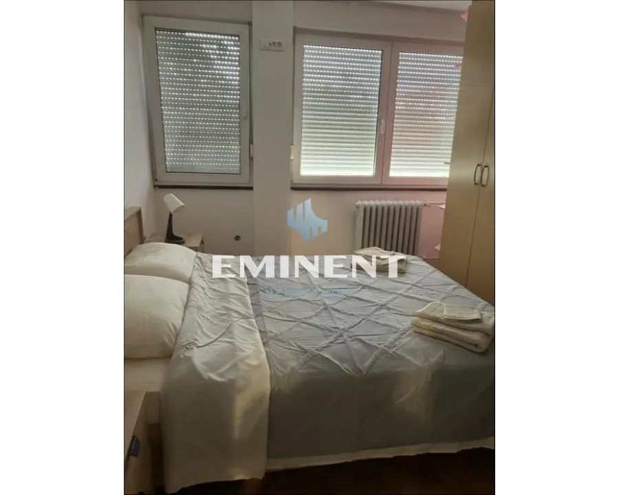 Bedroom with a double bed, wardrobe, and windows.