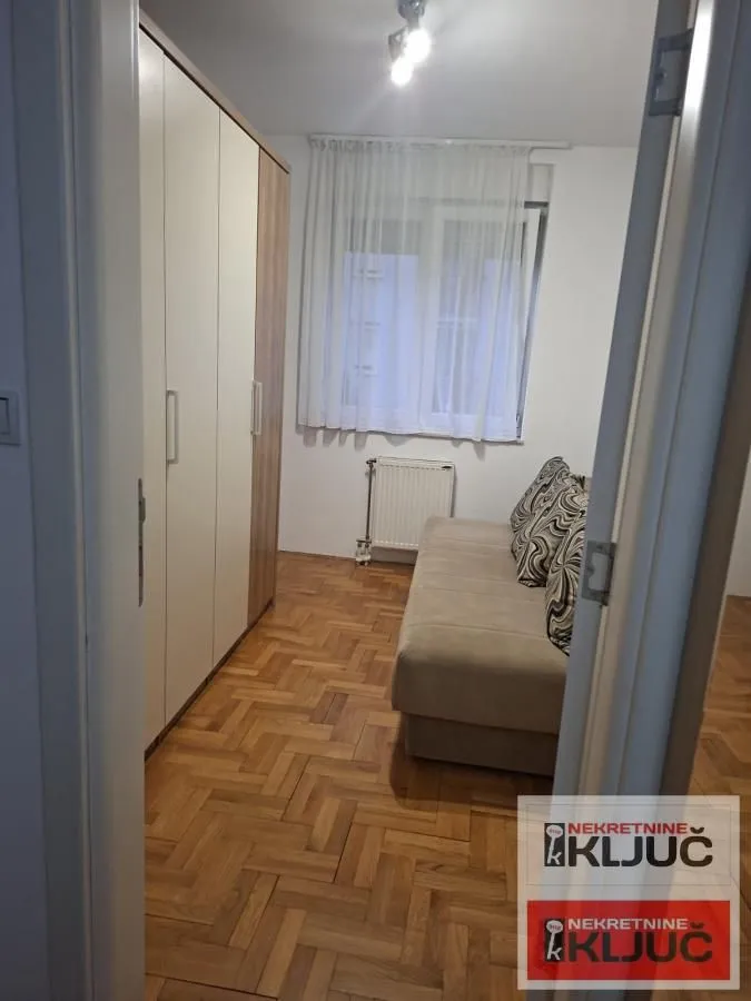 Manja spavaća soba sa krevetom na razvlačenje i velikim garderoberom.