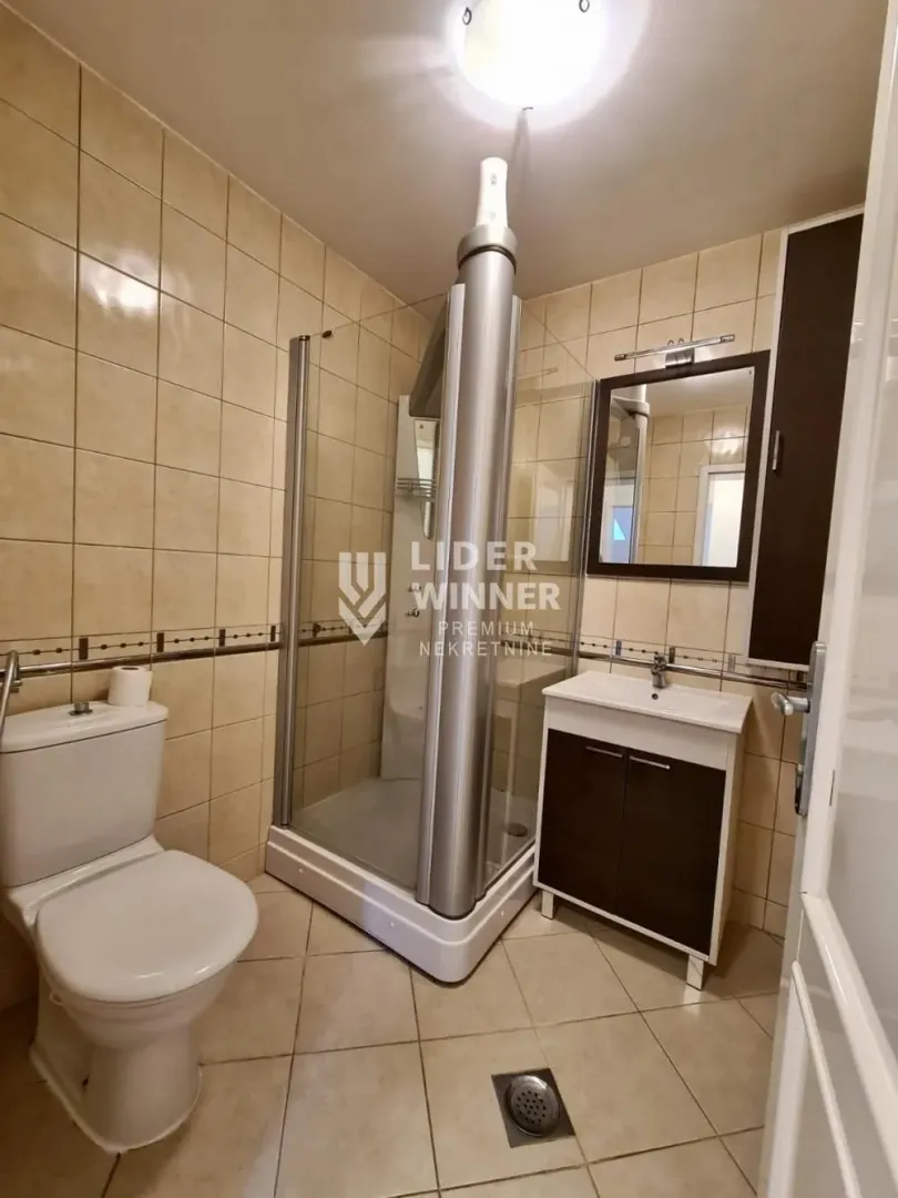 Manje kupatilo sa tuš kabinom, umivaonikom i wc šoljom.
