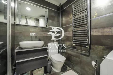 Savremeno opremljeno kupatilo sa umivaonikom, WC šoljom i ogledalom. - image 10