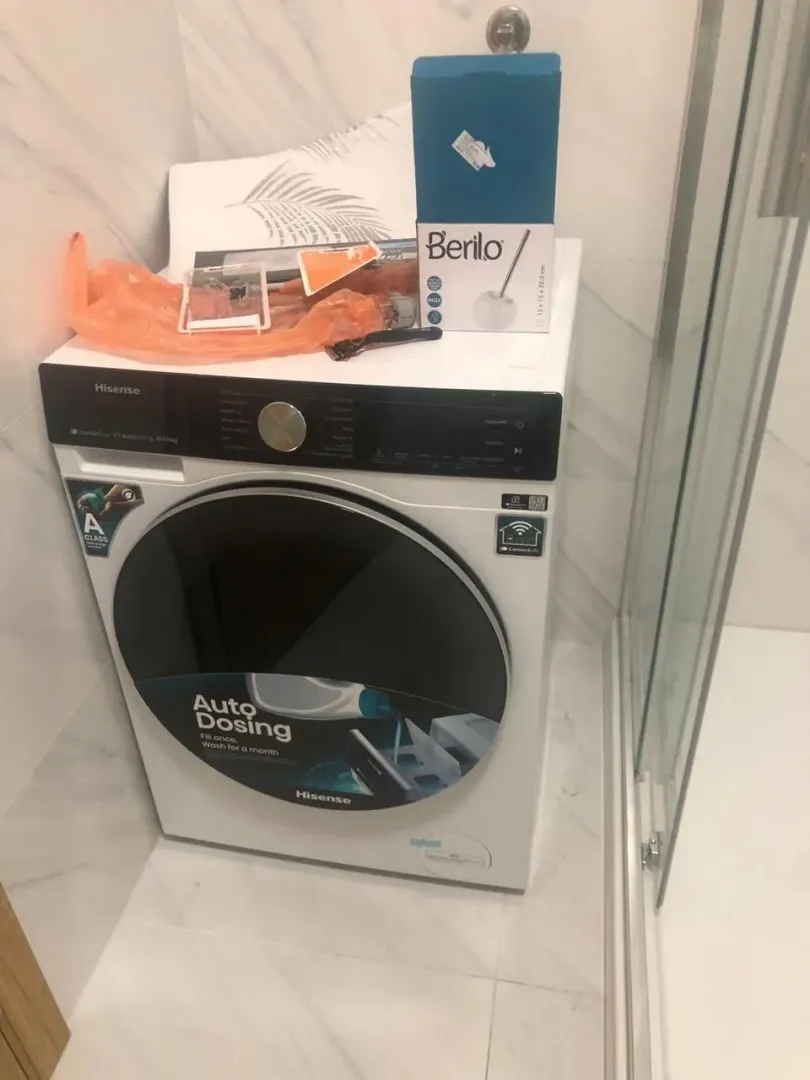 Washing machine in the bathroom next to the shower cabin.
