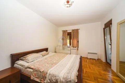 Spavaća soba sa bračnim krevetom, krevetcem za bebe i parketom na podu. - image 6