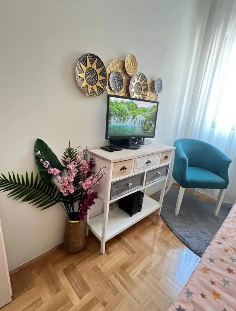 Decorated bedroom with a chest of drawers, TV, and decorative details.