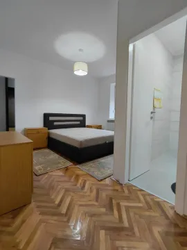 Bedroom with a double bed, parquet flooring, and a view of the bathroom. - image 4