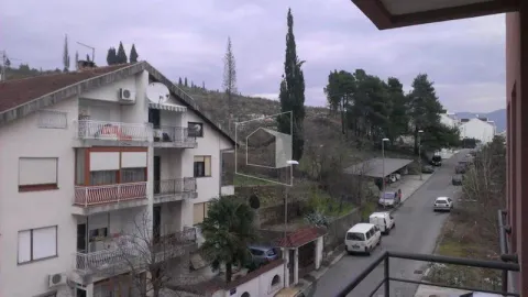View from the terrace overlooking the street, neighboring buildings, and surrounding greenery. - image 10