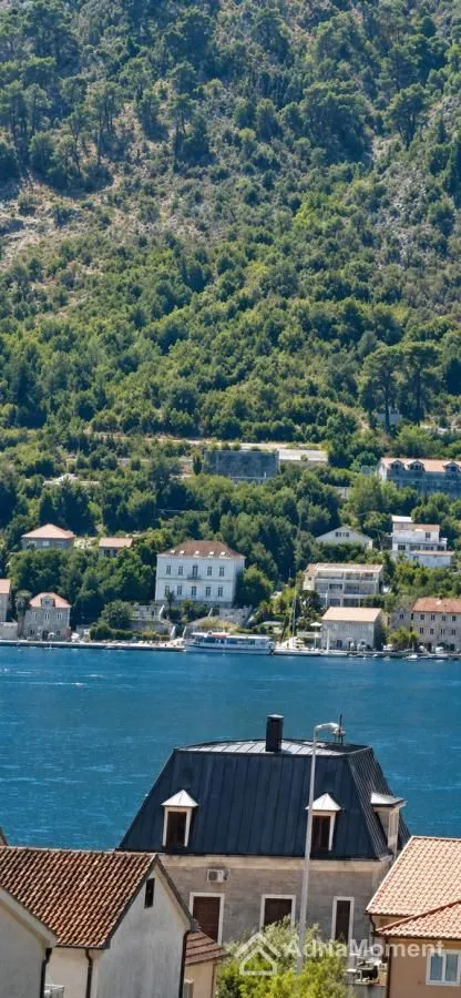 Pogled na more i okolno naselje sa zelenilom u pozadini.