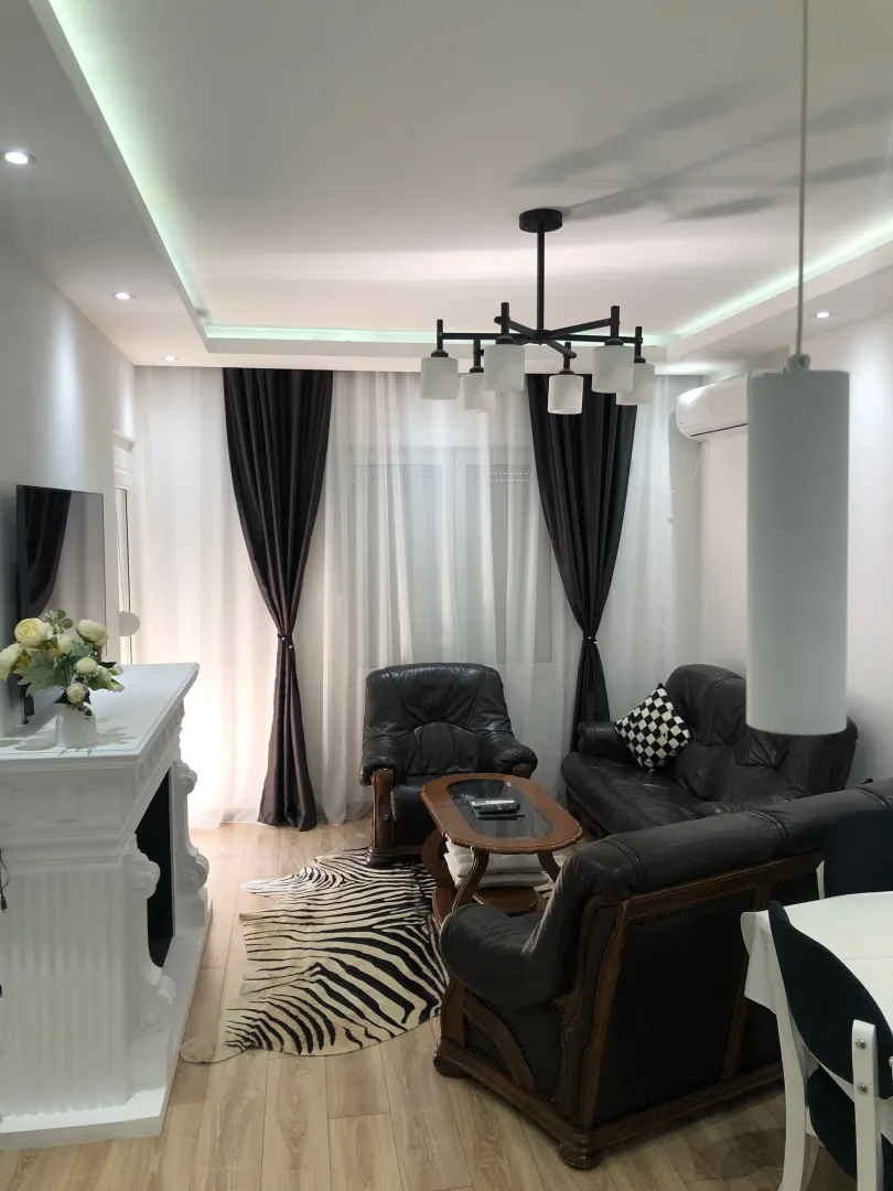 Living room with sofa set, fireplace, and dining table.