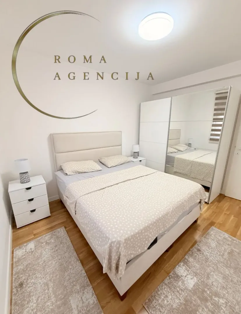 Bright and tidy bedroom with a double bed and wardrobe.