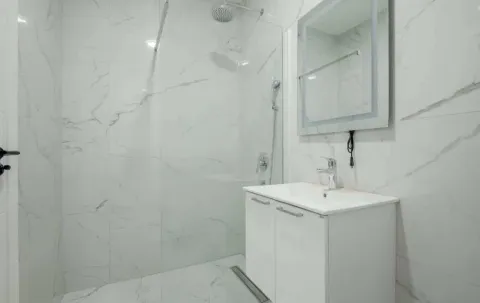 Moderne kupatilo sa bijelim mermernim pločicama, umivaonikom i tuš kabinom. - image 7