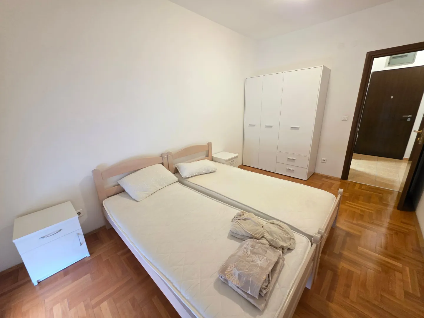 Bedroom with two single beds and a white wardrobe.
