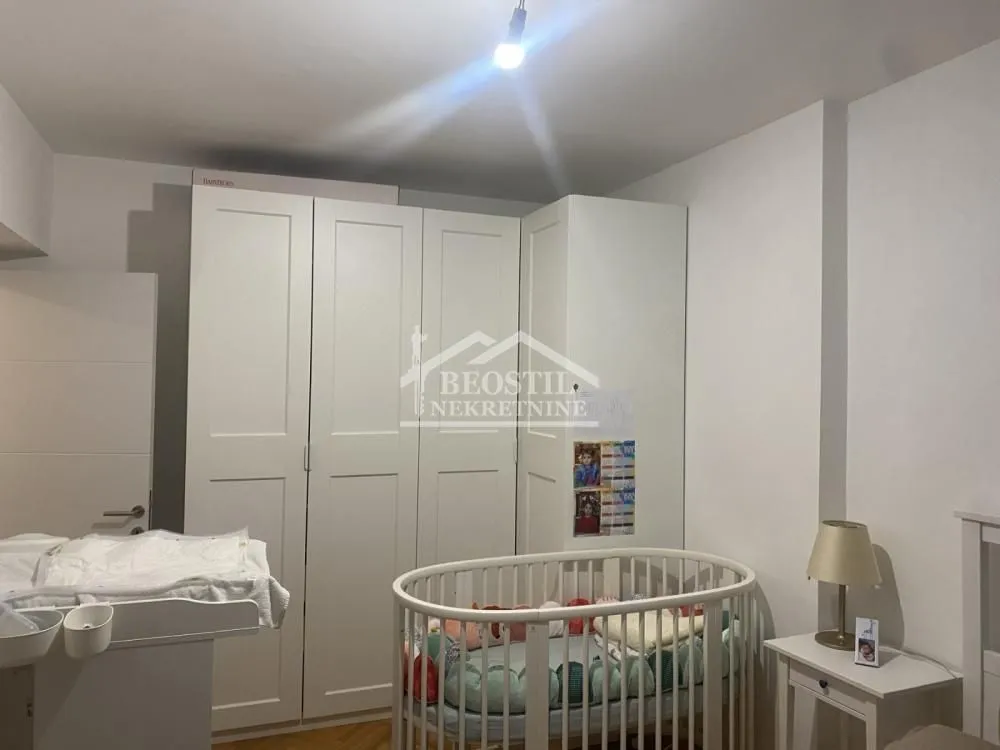 Children's room with a crib, wardrobe, and changing table.