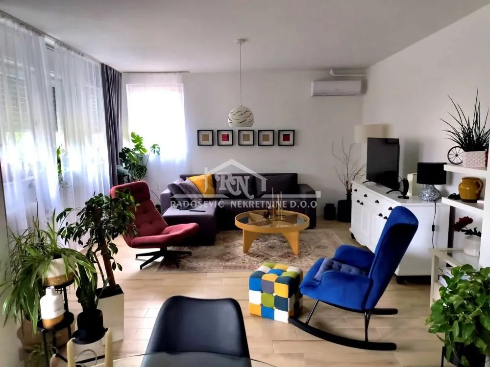 Dnevna soba sa garniturom, foteljama i trpezarijskim stolom.