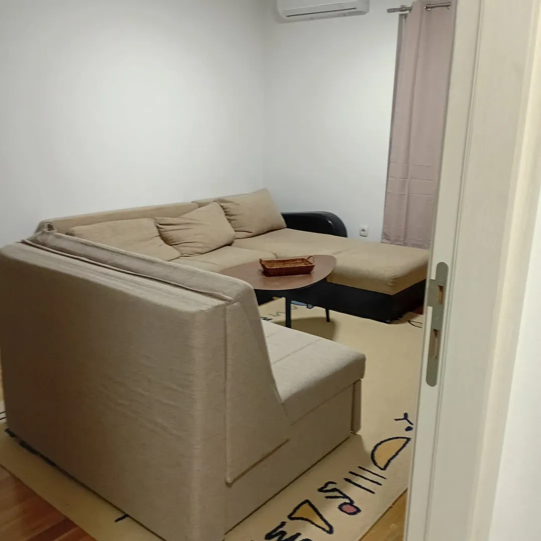 Dnevna soba sa ugaonom garniturom i stočićem.