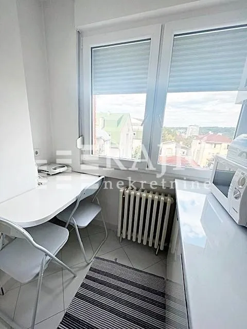 Small bright kitchen with a dining table and chairs by the window.
