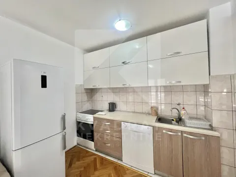 Small kitchen with white wall cabinets and wooden base cabinets. - image 4