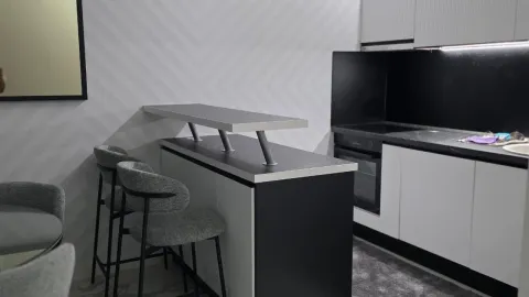 Modern kitchen with a breakfast bar and high chairs. - image 5