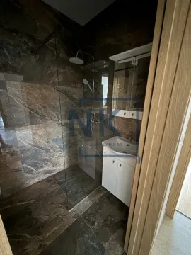 Savremeno opremljeno kupatilo sa tuš kabinom i umivaonikom. - image 8
