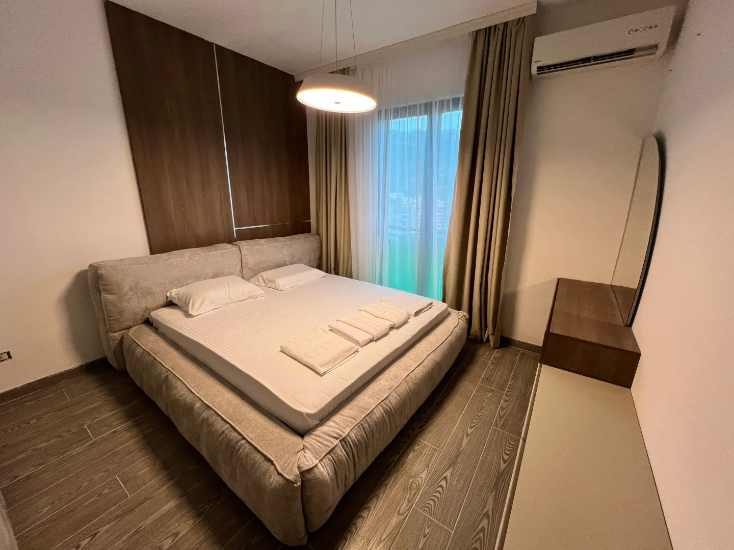 Modern bedroom with a double bed and wooden wall paneling.