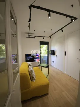 Dnevna soba sa žutim kaučem, televizorom i izlazom na terasu. - image 5
