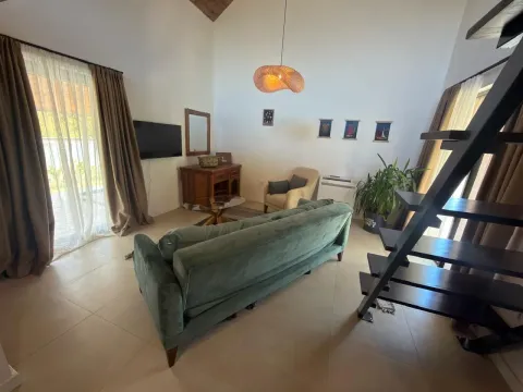 Spacious living room with a sofa, TV, and stairs leading to the gallery. - image 3