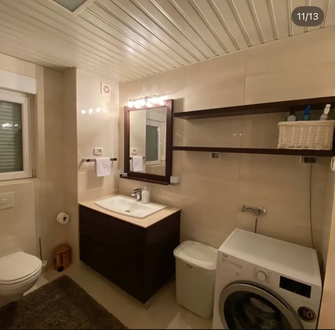 Fully equipped bathroom with a washbasin, toilet, and washing machine.
