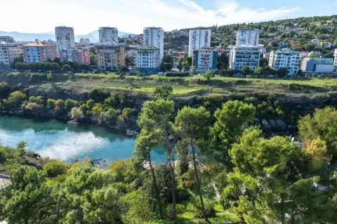 View of the river and cityscape with greenery. - image 8