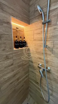 Moderan tuš sa zidnim pločicama u dezenu drveta i osvetljenom nišom. - image 8