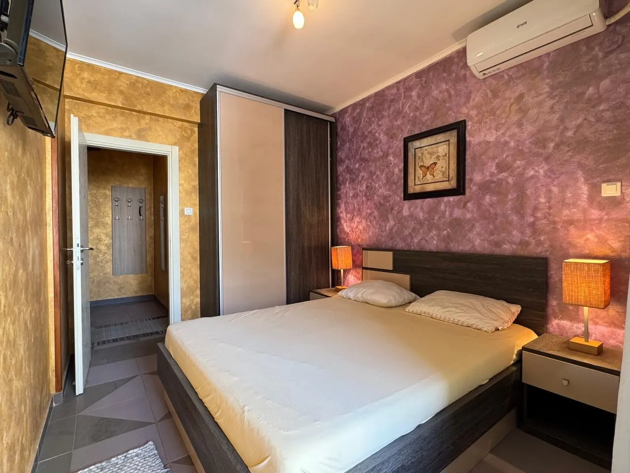 Bedroom with a double bed, wardrobe, and bedside lamps.