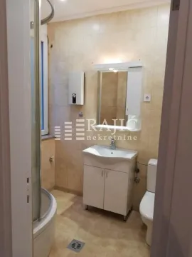 Smaller bathroom with a shower cabin, washbasin, and toilet. - image 7