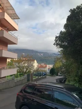 View of the driveway and surrounding buildings with hills in the background. - image 8