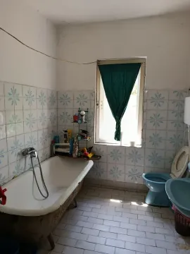 Starije kupatilo sa kadom, pločicama i prozorom. - image 9