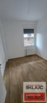 Prazna neopremljena soba sa drvenim podom i prozorom. - image 2