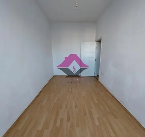 Empty room with laminate flooring and white walls.