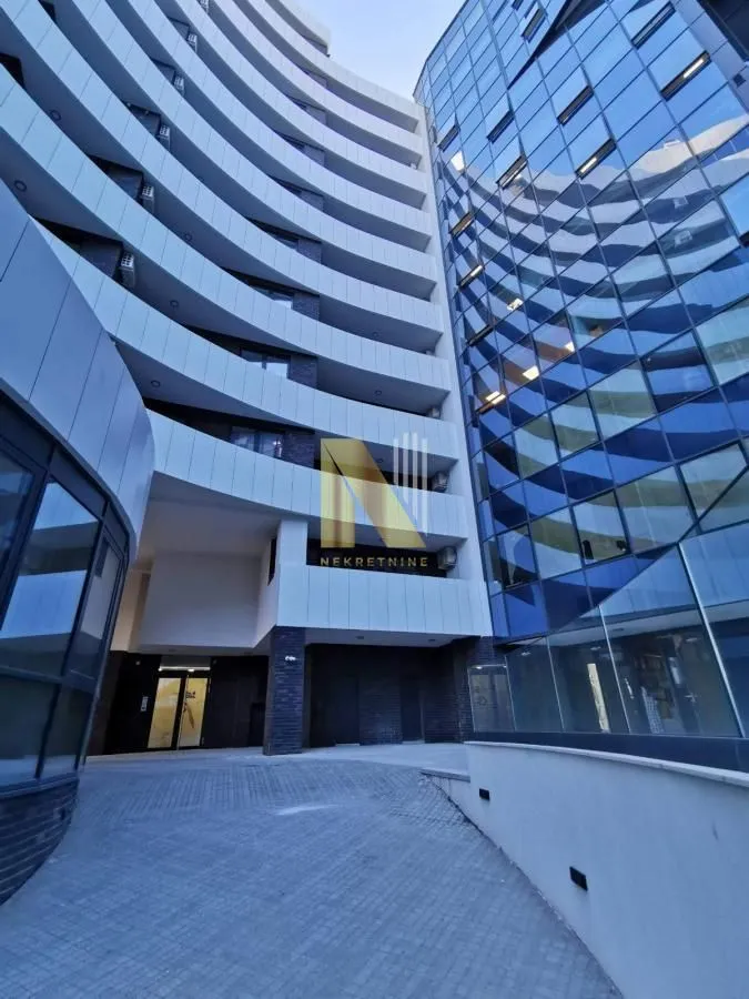 View of the exterior of a modern residential building with a paved courtyard.