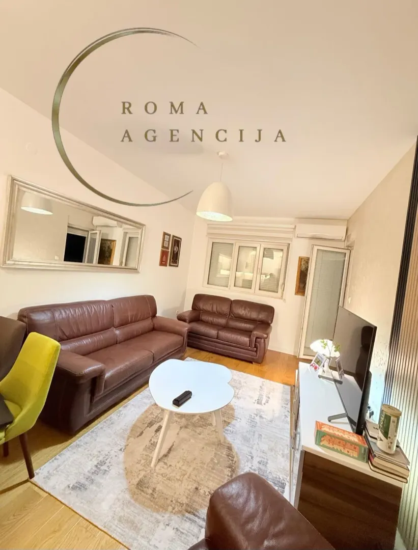 Living room with sofa set, coffee table, and television.